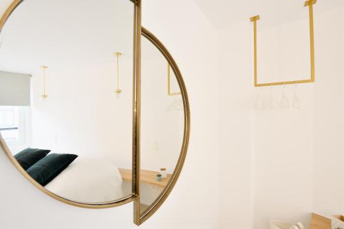 un espejo de oro grande colgando en una pared de un dormitorio en Urban Walls en Bruselas