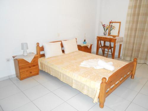a bedroom with a bed and a table and a chair at Chrysolithos Kerami Apartments in Khalkíon