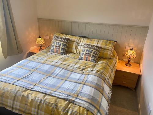 een slaapkamer met een bed en twee lampen op tafels bij Woodlands Hare Chalet, Bideford Bay Holiday Park in Bideford