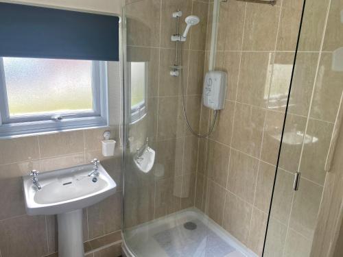 bagno con doccia, lavandino e doccia di Woodlands Hare Chalet, Bideford Bay Holiday Park a Bideford