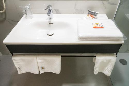 a bathroom with a white sink and towels at Blanca Hotel in Izmir