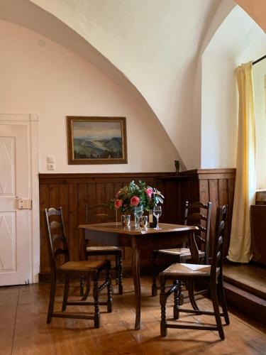 a dining room with a table with chairs and flowers on it at Schloss Greillenstein in Wutzendorf