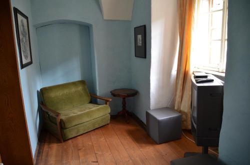 a living room with a green chair and a table at Schloss Greillenstein in Wutzendorf