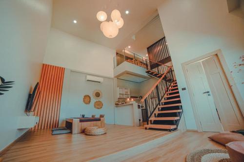 a living room with a staircase and a stair case at Wayla Villa@Maikhaobeach in Mai Khao Beach
