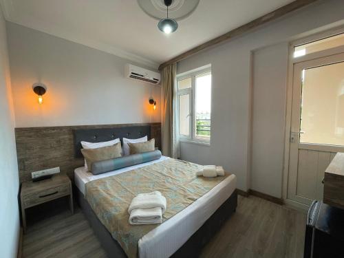 a bedroom with a bed with two towels on it at Seven City Hotel in Antalya