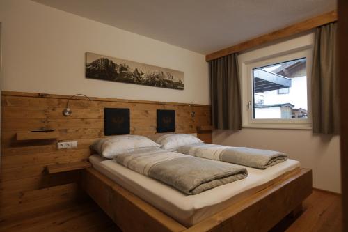 a bedroom with two beds on a wooden wall at Tiroler Ferienwohnungen Haus Petra in Kirchdorf in Tirol