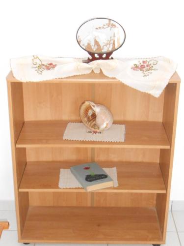 a wooden shelf with a bowl and a book at Chrysolithos Kerami Apartments in Khalkíon