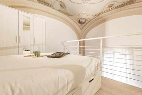 biała sypialnia z łóżkiem i sufitem w obiekcie Realkasa Luxury S.Orsola Apartments w Bolonii