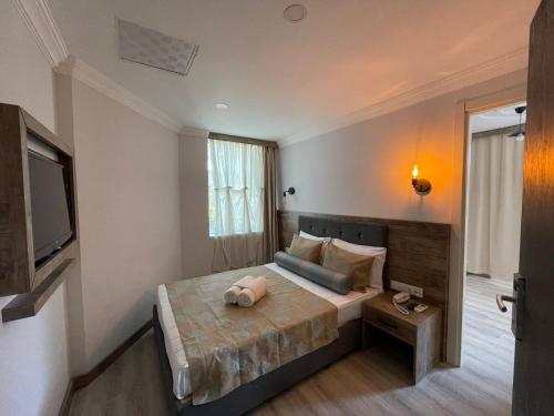 a bedroom with a large bed and a television at Seven City Hotel in Antalya