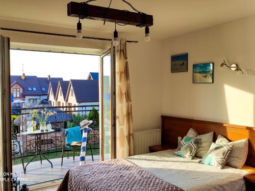 a bedroom with a bed and a sliding glass door at Pokoje gościnne Jolka in Łeba