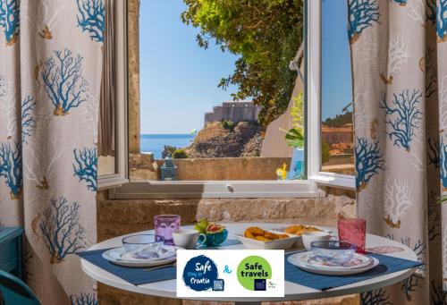 una mesa con platos de comida delante de una ventana en Villa Ani apartment Aquamarine, en Dubrovnik