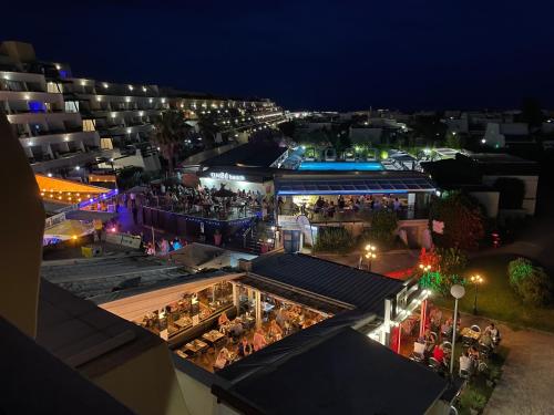 une foule de personnes debout sur le balcon d'un immeuble la nuit dans l'établissement SHOWTIME NATURISTE PORT NATURE 6 parking privé clim ascenseur vue mer, au Cap d'Agde