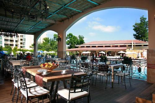 a patio with tables and chairs and a pool at Hotel Alba - All inclusive in Sunny Beach