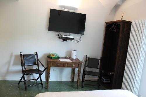 Cette chambre comprend un bureau avec deux chaises et une télévision. dans l'établissement Abracadabra Tortona, à Milan