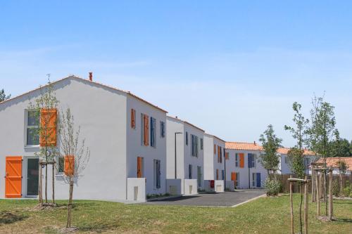 a group of buildings in a yard with trees at Pierre & Vacances Premium Les Villas d'Olonne in Les Sables-dʼOlonne