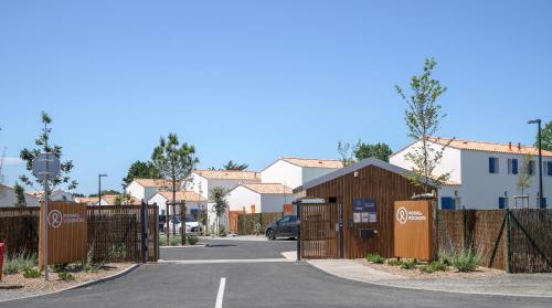 a parking lot with a fence and a building at Pierre & Vacances Premium Les Villas d'Olonne in Les Sables-dʼOlonne