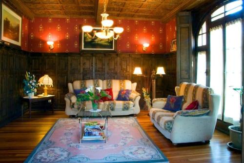 a living room with two couches and a table at Hotel Palacete Real in Villamayor