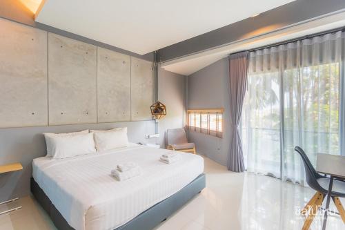 a bedroom with a large white bed and a window at Wara Boutique Hotel in Udon Thani