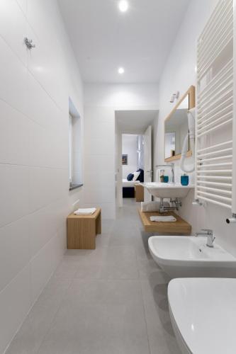 a white bathroom with two sinks and a mirror at HSuites Luxury B&B in Castellammare di Stabia