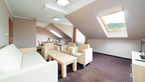 a waiting room with white chairs and a skylight at Apartamenty Sun & Snow Sofra in Karpacz