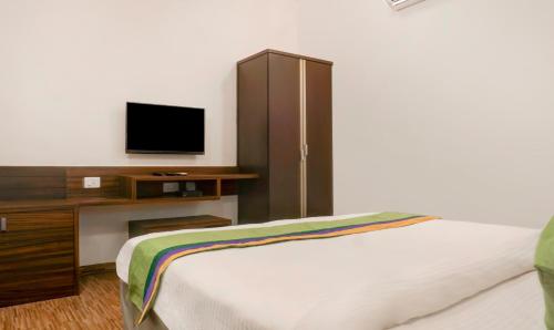 a bedroom with a bed and a cabinet with a television at Treebo Five Elements, Lonavala in Lonavala
