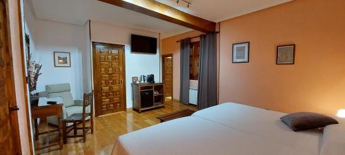 a bedroom with a white bed and a desk and a chair at Hosteria Picos De Europa in Potes