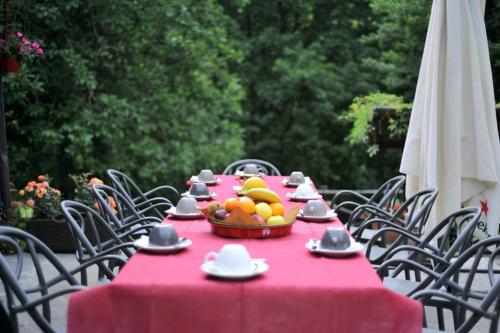una mesa con mantel rojo y un tazón de fruta en Eremo Montemezzano, en Pratovecchio