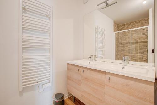 une salle de bain avec un lavabo et un miroir dans l'établissement À 600m de la plage, bel appartement pour 6, à Lacanau