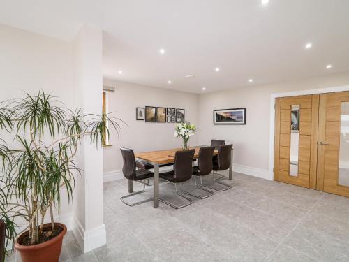 a dining room with a table and black chairs at Traeannagh Bay House in Dungloe