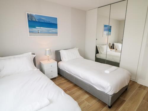 a bedroom with two beds and a mirror at Traeannagh Bay House in Dungloe