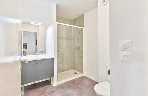 une salle de bain blanche avec douche et toilettes dans l'établissement Confort et bel appartement au coeur de Lacanau, à Lacanau