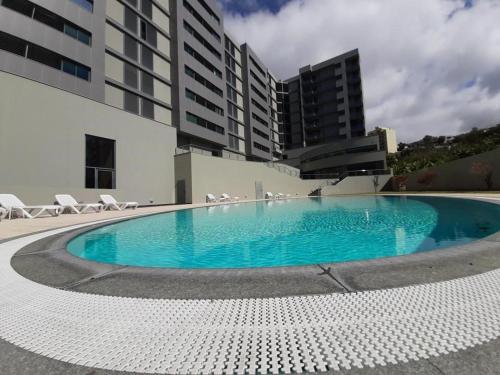 a large swimming pool in front of a building at Angel's Apartment in Funchal