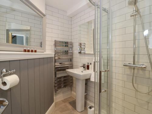a white bathroom with a sink and a shower at 5 Riverside in Bridgnorth