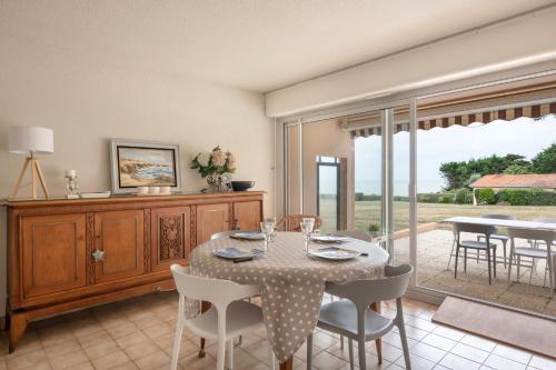 une salle à manger avec une table et des chaises et une fenêtre dans l'établissement Rez-de-terrasse face mer pour 4 personnes, à Pornic