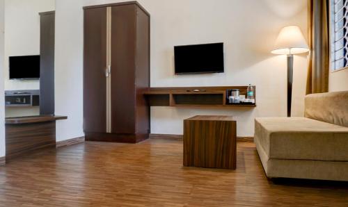 a living room with a couch and a tv at Treebo Five Elements, Lonavala in Lonavala
