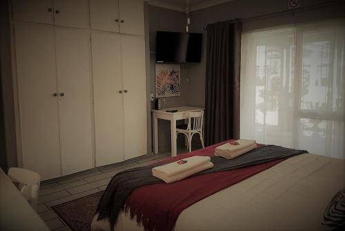 a bedroom with a bed with two towels on it at Graceland Guesthouse in Potchefstroom
