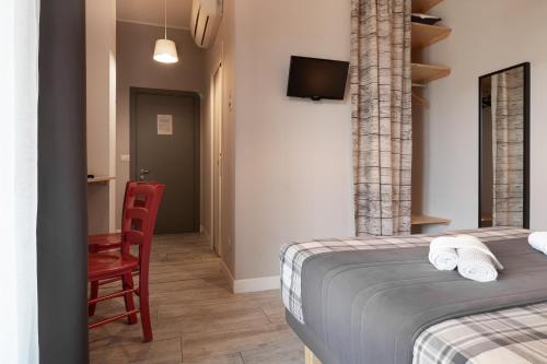 a bedroom with a bed and a red chair at Bed and Breakfast Bric & Brac in Grottammare