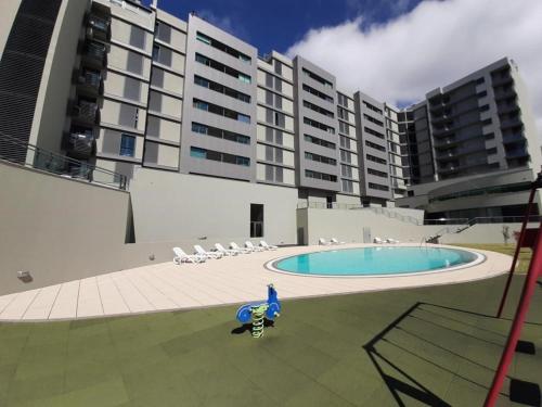 a large building with a swimming pool in front of it at Angel's Apartment in Funchal