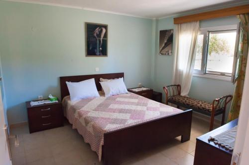 a bedroom with a bed and a chair and a window at OLIVES Estate APARTMENTS Grande in Preveza