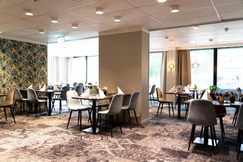 a dining room with tables and chairs and windows at Thon Partner Hotel Otta in Otta