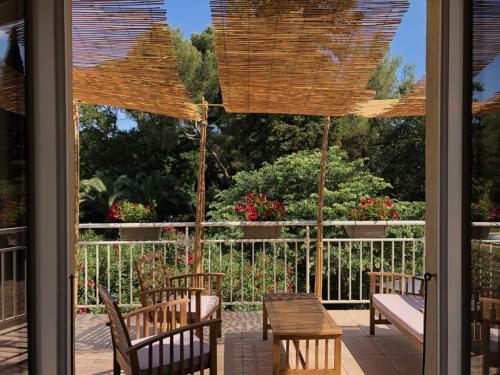 eine Veranda mit einem Tisch und Stühlen sowie Gartenblick in der Unterkunft Le Nid des Corbières in Bizanet