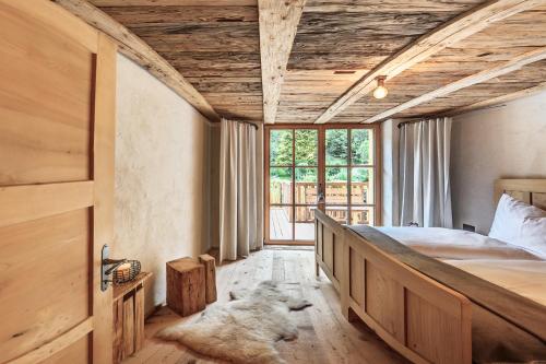 a bedroom with a large bed and a large window at Lass Zeit am Lech in Bach