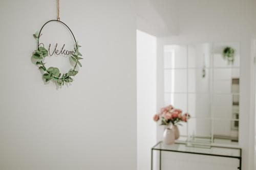 Habitación con espejo y jarrón de flores en SunsetView Apartment, en Oradea