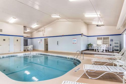 a swimming pool in a room with chairs and a table at Sleep Inn Austintown - Youngstown, West in Austintown