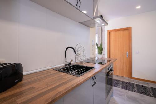 a kitchen with a sink and a wooden counter top at Terra & Mar - Land & Sea in Arcozelo