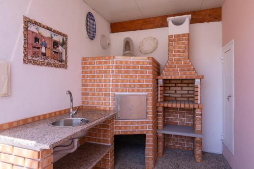 a brick kitchen with a sink and a ladder at Terra & Mar - Land & Sea in Arcozelo