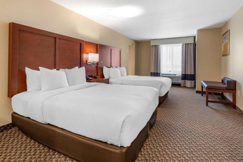 a hotel room with two beds and a desk at Comfort Suites Broomfield-Boulder-Interlocken in Broomfield