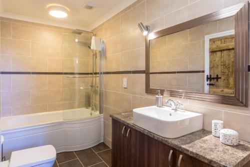 a bathroom with a sink and a toilet and a tub at Ty Llo in Kidwelly