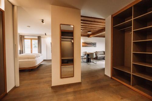 a room with a bedroom and a bed and a mirror at Weinhotel Maitz Wolfgang in Ratsch an der Weinstraße