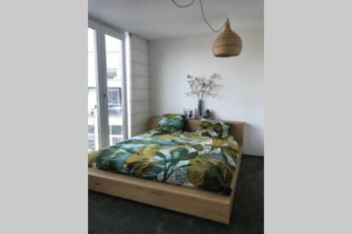 a bedroom with a bed and a window at Large and cosy house on the water: free Parking in Amsterdam